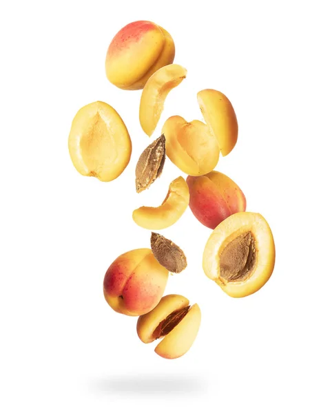 Ganze und in Scheiben geschnittene frische Aprikosen in der Luft, isoliert auf weißem Hintergrund — Stockfoto