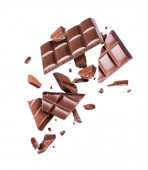 Čokoláda rozbité na mnoho kousků ve vzduchu na bílém pozadí 