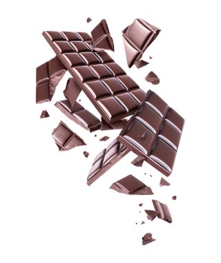 Bütün ve ezilmiş çikolatalar beyaz bir arka planda havada. 