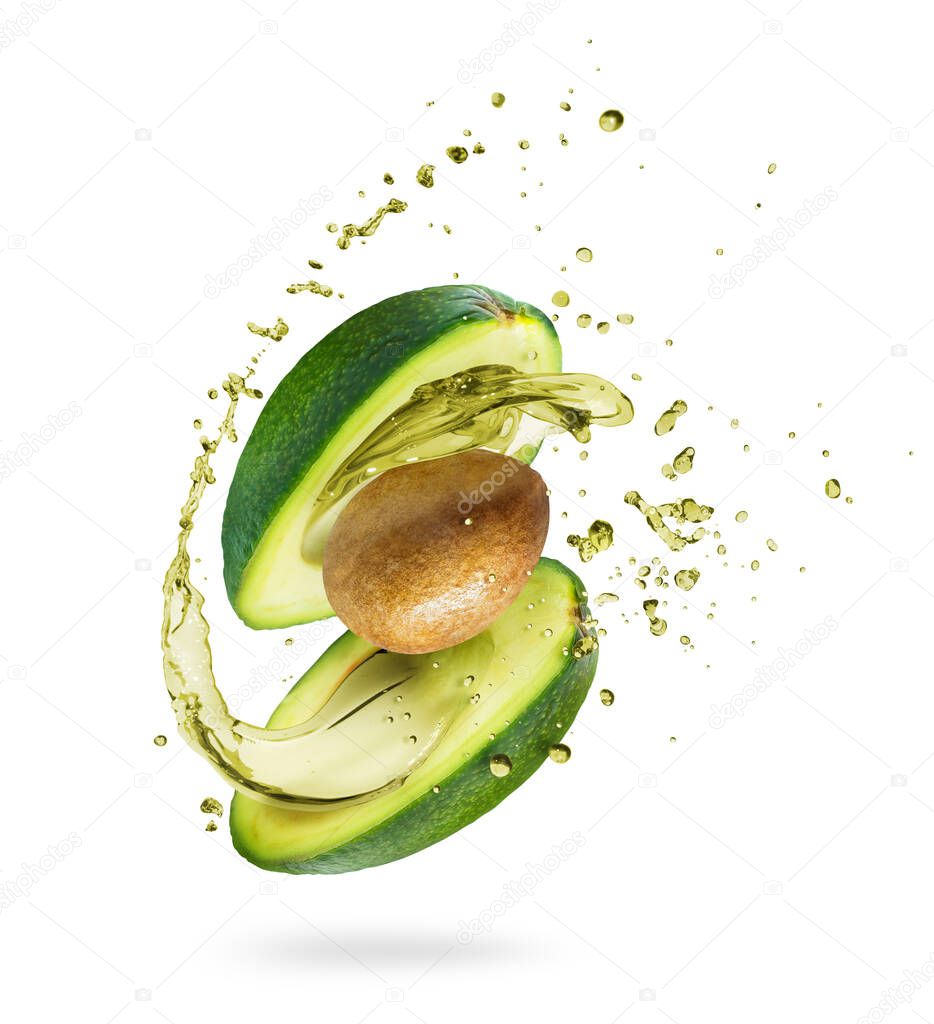 Sliced avocado with splashes of juice close-up, isolated on a green background