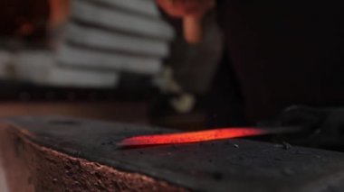 Bir bıçak sıcak çelik yapma. Ağır çekim. Demirci iş. Kömürlerin yanma. Erimiş çelik bir çekiç ile çekiç