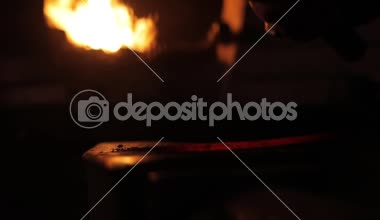 Bir bıçak sıcak çelik yapma. Ağır çekim. Demirci iş. Kömürlerin yanma. Erimiş çelik bir çekiç ile çekiç