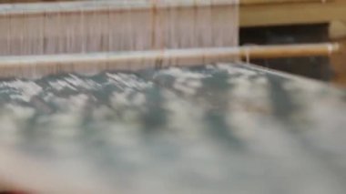 Kadın bir tezgah üzerinde bir kumaş örgüleri