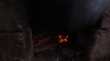 Bir adam fırın yangın kindles. Ağır çekim.