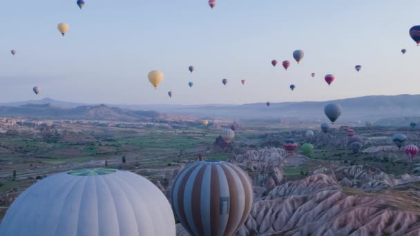 许多五颜六色的热气球在山上飞行 日出时卡帕多西亚的全景 卡帕多西亚戈雷梅山谷的广阔景观 空中调查 空中射击 — 图库视频影像