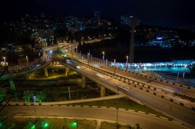Bir kavşakta kentsel trafiğin gece aydınlatması, Soçi. Timelapse.