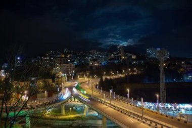 Bir kavşakta kentsel trafiğin gece aydınlatması, Soçi. Timelapse.