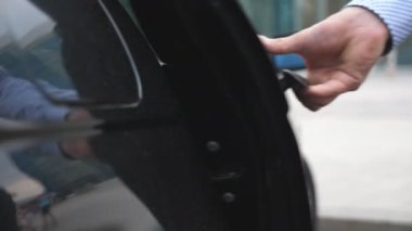 El erkek işadamı açar ve arabanın kapısını güzel genç kadın için tutar. Adam açılış kapı otomobil kadın yolcu için. Otomatik gir. Yavaş hareket kapatmak