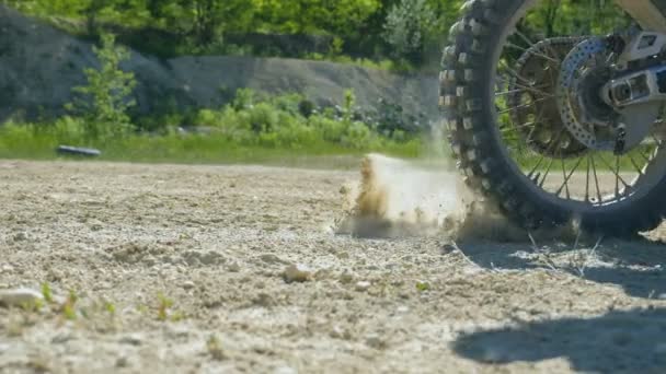 Roue de moto-cross commence à tourner et à botter le sol ou la saleté. La moto démarre le mouvement. Ralenti Fermer 