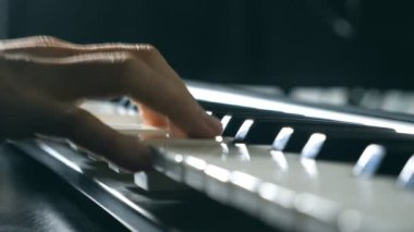 Piyanist piyano tuşları, parmakları kapatın. Mens silah çalış solo müzik veya yeni melodi. Eller erkek müzisyen synthesizer oynarken. Yavaş hareket üstten görünüm izole atış