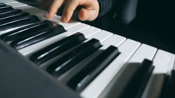 Dolly shot of male hands of musician playing at synthesizer at sound recording studio. Mens arms plays solo of music. Close up fingers of pianist at the piano keys. Slow motion — Stock Video