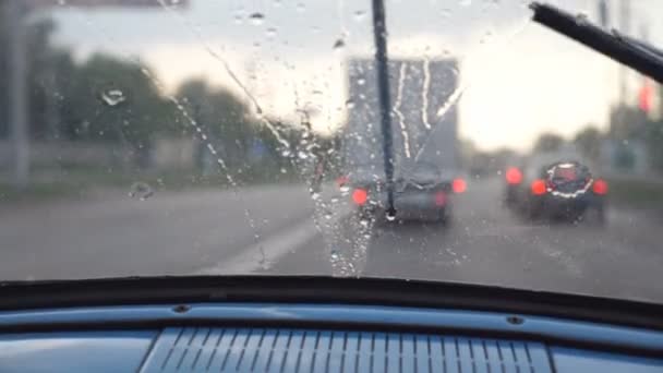 Punto de vista desde el asiento delantero hasta el parabrisas del viejo coche retro durante el mal tiempo. Limpiaparabrisas eliminar las gotas de lluvia de la ventana del automóvil vintage durante el viaje en la carretera. Primer plano: cámara lenta — Vídeos de Stock