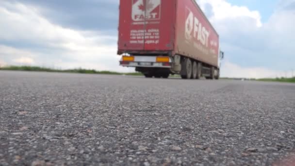 De weergave van de lage hoek van twee trucks rijdt op lege snelweg met zonnige zomerdag. Semi-vrachtwagens vracht vervoeren lading op asfaltweg bij platteland. Vervoer en logistiek concept. Achterkant dicht een back-up — Stockvideo