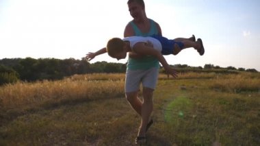 Baba ve oğul güneşli yaz gününde sahada oynuyor. Mutlu baba tutarak ve küçük çocuğunu elinde döner. Çocuk gibi bir uçak uçar hayal. Mutlu bir aile vakit açık. Ağır çekim