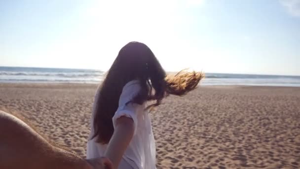 Seguimi mentre una giovane donna tira il suo ragazzo sulla riva del mare. Ragazza che tiene la mano maschile e corre sulla spiaggia tropicale esotica verso l'oceano. Vacanze estive o vacanze. Punto di vista. POV rallentatore — Video Stock