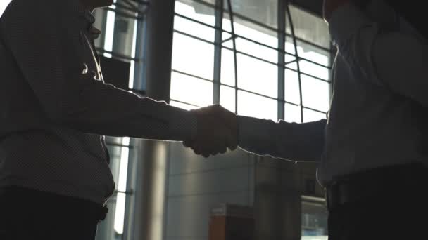 Two businessmen farewell with each other in office. Colleagues shake hands and diverge. Business handshake indoor. Shaking of male arms inside. Close up Slow motion — Stock Video