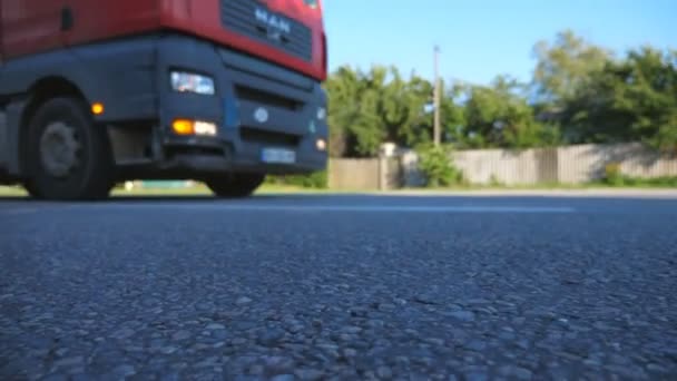 Samochód ciężarowy jest jazda wzdłuż drogi asfaltowej. Niewyraźne samochód jest jazda na autostradzie w letni wieczór. Slow motion z bliska — Wideo stockowe