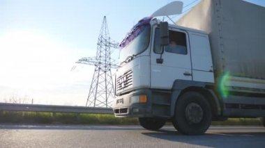 Kamera bir otoyolda kamyon için izler. Arka plan günbatımı ile kırsal yoluyla hız kamyon. Alt tarafı görünümü ağır çekim yakın çekim