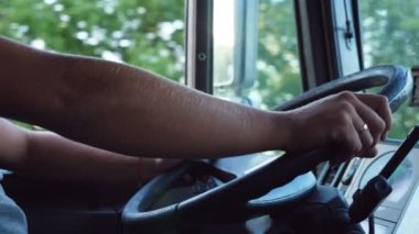 Tanınmayan adam ellerini direksiyonun üzerine basılı tutup ülke Road üzerinde sıcak yaz günü araba. Kamyon şoförü ile hedefe gidiyor. Kamyon taksiden görüntüleyin. Ağır çekim yakın çekim