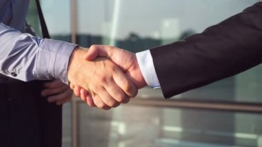 Dolly başarılı anlaşma Ofis Binası yakınındaki sonra el sıkışan iki iş adamları bir kadeh. Her diğer içinde kentsel çevre tebrik genç meslektaşlarının kapatın. Karşılıklı iş ortakları