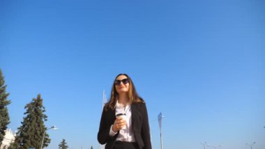 Take away kahve tutarak ve kentsel cadde boyunca yürüyen genç iş kadını. İş kadını işe yarayacak. Kendine güvenen kız ofis giderken. Alt görünümü ağır çekim yakın çekim