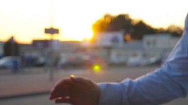 Şehir sokak üzerinde toplantı ve dostça bir firma el sıkışma sahip iki iş adamları yakın çekim. Birbirlerini tebrik ve otopark arabalar arka planı el sallayarak genç meslektaşlarım. Ağır çekim