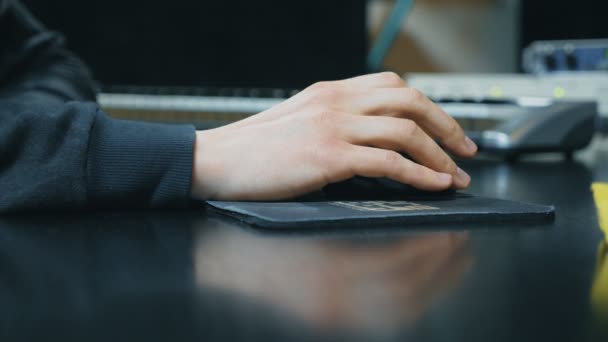 Mano masculina controla el ratón del ordenador mientras trabaja en el estudio de sonido. Trabajo creativo en el estudio de grabación. Hombre usando computadora. Vista lateral cámara lenta Primer plano — Vídeos de Stock