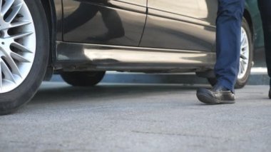 Sürücü arabaya geliyor ve iş adamına kapıyı açıyor. Şoför, erkek yolcular için otomobilin kapısını açtı. İşadamı arabadan indi ve ofis binasına gitti. Yavaş Hareket