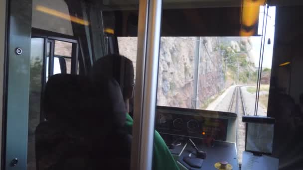 Αγνώριστος οδηγός τρένου οδηγεί ηλεκτρικό τρένο μεταξύ ορεινό δρόμο. Από άποψη οπτικής γωνίας από θάλαμο μηχανοδηγού έως σιδηροδρομικές γραμμές. Οπίσθια όψη πλάτης POV Αργή κίνηση Κλείσιμο — Αρχείο Βίντεο