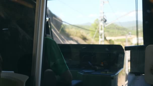 Unrecognizable train driver drives electrical train among mountain road. Point of view from driver cabin to railway tracks. Rear back view POV Slow motion Close up — Stock Video