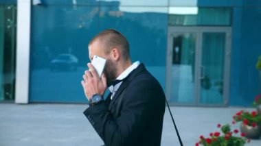 İş adamı telefonda konuşuyor ve başarıyı kutluyor. Genç iş adamı cep telefonundan iyi haberler duymuş ve olumlu duygular besliyor. Erkek portresi başarıyla mutludur. Dolly vurdu.