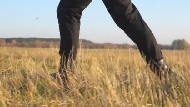 Ноги солдата в черных сапогах бегут по полю и наступают на сухую траву. Мужчина спортсмен тренируется и тренируется на открытом воздухе. Красивая природа на заднем плане. Военное понятие. Медленное движение — стоковое видео