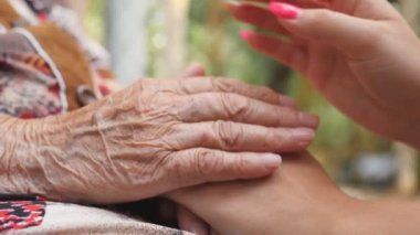 Eski buruşuk ve genç erkek ve rahatlatıcı ve açık diğer her okşayarak eller. Torunu ve birlikte vakit büyükanne. Bakım ve kavram sevgi dolu. Yan görünümü ağır çekim kapatın.