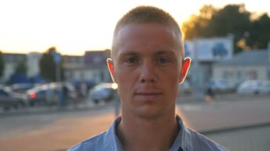 Gömlek ayakta şehir ortamı, yakışıklı başarılı adam portresi yakın çekim içine kamera on sunset Park Arabalar arka planı arıyorum Genç emin iş adamı