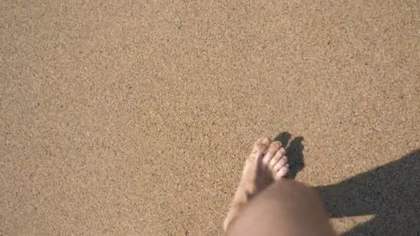 Pohled na mladého muže, jak kráčí po zlatém písku na mořské pláži. Mužské nohy kráčející blízko oceánu. Bosá noha chlapa, co jde na písečný břeh s vlnami. Letní dovolená nebo dovolená Zpomalený pohyb Zavřít POV — Stock video