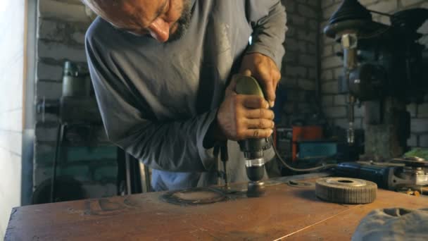 Mani di utensile meccanico tenere durante il funzionamento. Un uomo lavora nel suo garage. Il lavoratore elabora il dettaglio su desktop. Concetto di duro lavoro. Rallentatore Close up Dolly shot — Video Stock