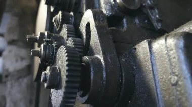 Döndürme dişli sistemi kapatın. Alt görünümü garajda çalışma metal tezgah kirli iplik cogwheels üzerinde. Arka plan bulanık. Ağır çekim yakın çekim