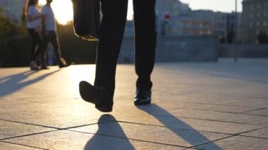 Şehirde günbatımı zaman sokak yürüyüş evrak çantası ile işadamı metrelik. Çalışmaya commuting bir iş adamı. Kendine güvenen adam büroya yolda olmak. İşçi açık olacak. Önden görünüm kapatmak yavaş hareket