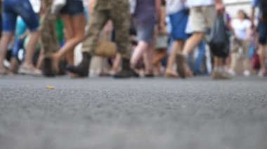 Büyük şehirde yaz günü, tanınmayan yayaların kavşaktan karşıya geçerken alçak açılı görüntüsü. Şehir merkezinde yaya geçidinde yürüyen bir kalabalık. Kentsel yaşam tarzı kavramı. Bulanık hareket. Yavaş çekim
