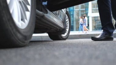 İşadamı açar ve araba güzel genç kadın için kapıyı tutar. Otomatik dışarı almak yüksek topuklu ayakkabılarla işkadını ince bacakları. Ağır çekim düşük açılı görünümü kapatın