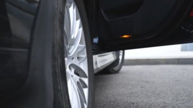 İşadamı açar ve araba güzel genç kadın için kapıyı tutar. Otomatik dışarı almak yüksek topuklu ayakkabılarla işkadını ince bacakları. Ağır çekim düşük açılı görünümü kapatın