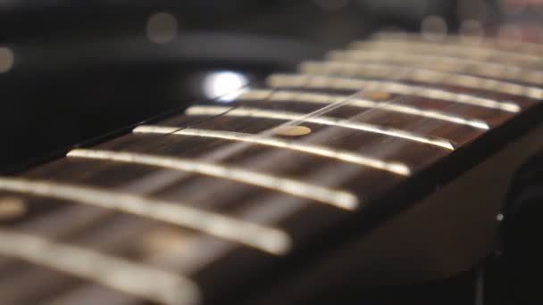 Close up of trembling guitar strings against fret. Chords being strummed and vibrating during playing. Beautiful background with wooden texture. Music performance. Blurred motion. Top view Slow motion — Stock Video