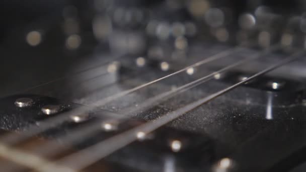 Close up de dedos masculinos tocando cordas de um instrumento musical. Acordes sendo dedilhados e vibrando. Mão de homem praticando para tocar guitarra elétrica em estúdio. Desempenho musical. Movimento lento — Vídeo de Stock