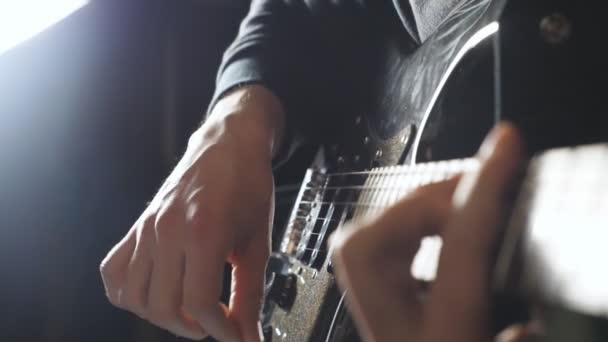 Egy srác keze, aki szólóban játszik a rockzenében. Az elektromos gitáron játszó zenész karjainak bezárása. A gitáros férfi ujjai mozgatják a húrokat. Felnőtt ember komponál egy új dallamot. Lassú mozgás. — Stock videók