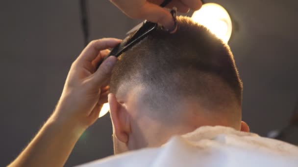 Mani maschili di pettinatura di parrucchiere e taglio di capelli di cliente da spazzola per capelli e forbici in barbiere. Braccia di capelli di bordatura di barbiere di cliente in salone. Processo di acconciatura. Vista posteriore rallentatore — Video Stock