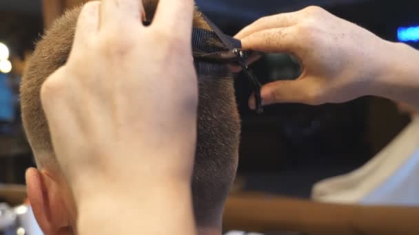 Arme des Friseurs schneiden Haare des Kunden im Friseursalon. Männliche Hände des Friseurs kämmen und schneiden die Haare des Kunden mit Haarbürste und Schere im Salon. Haarstyling-Prozess. Rückansicht Zeitlupe — Stockvideo