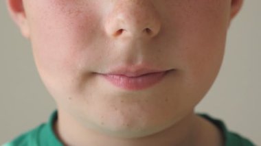 Ayrıntı görünümü mutlu çocuk yüzünde. Gülümseyen genç çocuk yakın çekim. Yüzündeki mutlu ifadeyi ile yakışıklı çocuk portresi. Ağır çekim