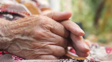 Yaşlı bir kadının kırışık kolları dışarıda. Büyükannem dışarıda ellerini okşuyor. Yan Görünümü Kapat Yavaş Çekim