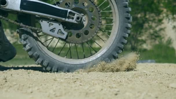 Rueda de moto de motocross empezando a girar y patear el suelo o la suciedad. La motocicleta inicia el movimiento. Cámara lenta Primer plano — Vídeo de stock