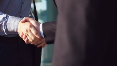 Her diğer ofis binası yakınındaki tebrik başarılı İşadamlarından kapatın. Toplantı ve kentsel ortamda el sıkışan iki genç arkadaşları. Karşılıklı iş ortakları açık. Ağır çekim